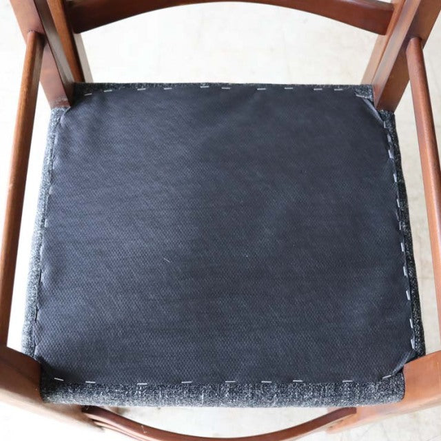 Mid-century vintage teak dining chair seat with smooth black upholstery and visible wood grain frame from British Denmark.