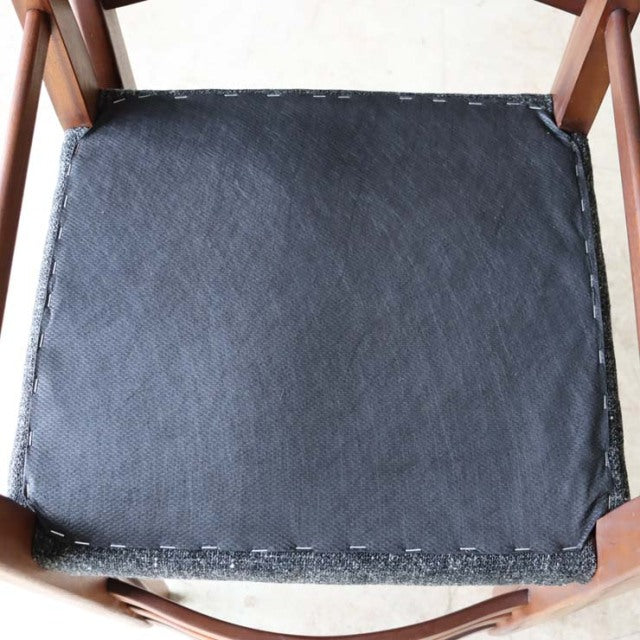 Mid-century British vintage teak dining chair seat with black vinyl upholstery and visible stapled edges.