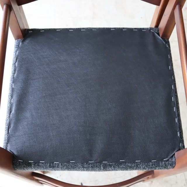 Vintage teak dining chair seat with newly upholstered black fabric, showcasing mid-century British craftsmanship and visible .