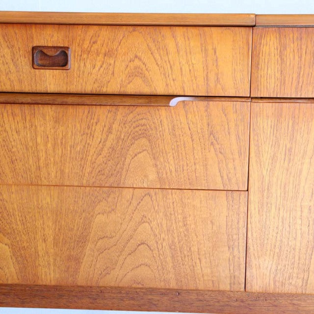 Mid-century British vintage teak sideboard with rich wood grain, inset handle, and smooth drawer fronts.