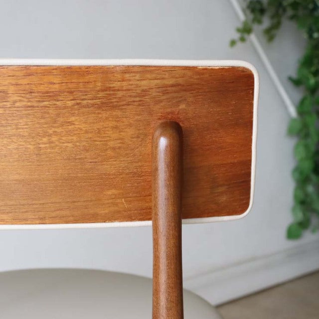 Pair of British mid-century G-plan teak dining chairs featuring rich wood grain and rounded vertical supports.