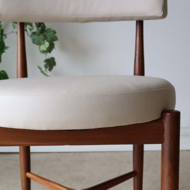 Set of two G-Plan mid-century British vintage dining chairs in teak with cream upholstered cushions and tapered legs.