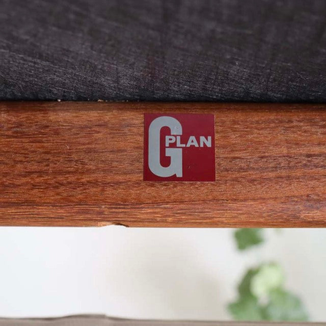Close-up of G-Plan vintage teak wood frame with visible grain and embossed red and white brand label, mid-century British.