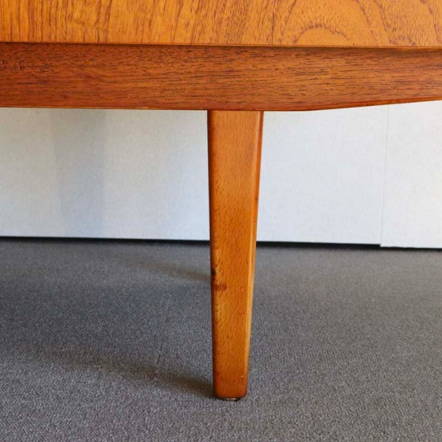 Mid-century teak leg of British vintage sideboard with warm wood grain and tapered design.