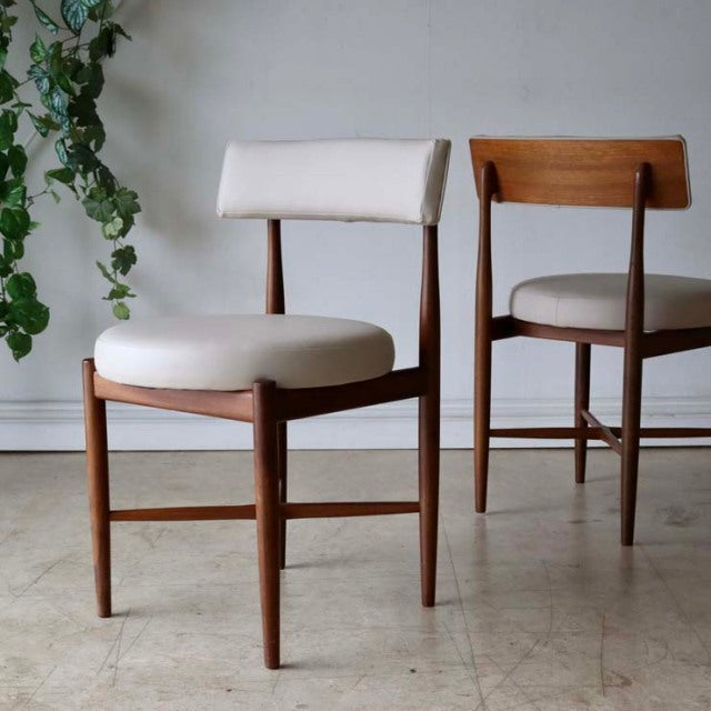 Set of two G-Plan vintage mid-century dining chairs in teak with curved backrests and cream upholstered seats, sleek British .