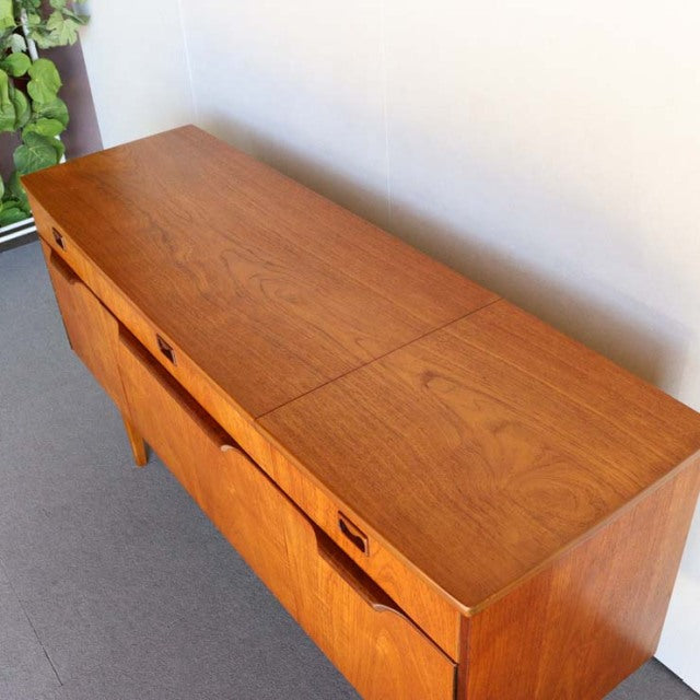 Mid-century British vintage teak sideboard with clean lines, smooth wood grain, and tapered legs.