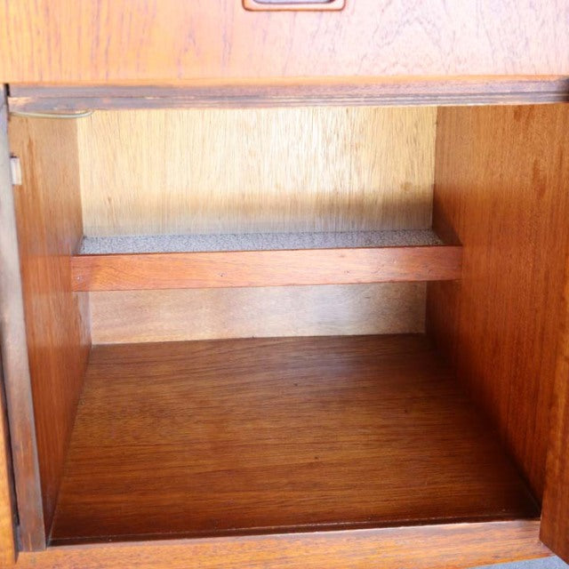 Mid-century British vintage teak sideboard interior with rich wood grain and clean lines, showcasing solid teak shelf and.