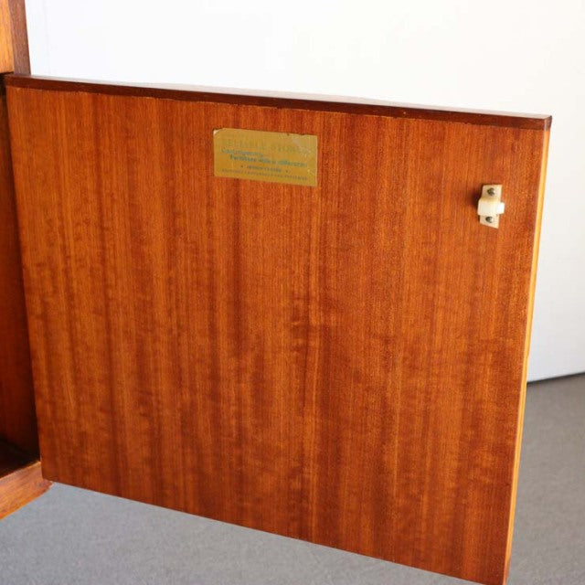 Vintage teak sideboard panel with rich wood grain, mid-century British design, brass label, and latch detail.