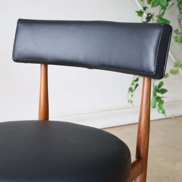 Mid-century British G-plan dining chair with vintage teak frame and black leather padded seat and backrest.