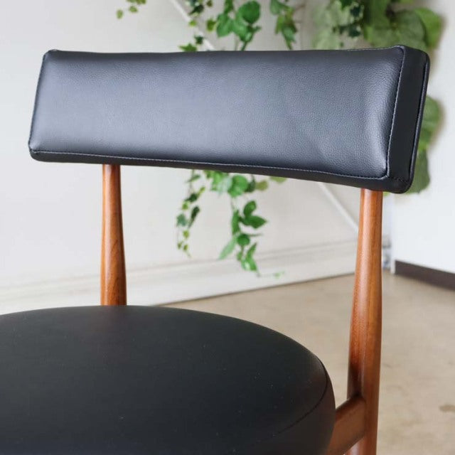 Set of four vintage G-plan mid-century dining chairs in teak with black leatherette seats and backs, showcasing teak wood.