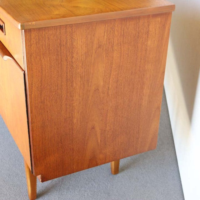 Mid-century vintage British teak sideboard with smooth wood grain and tapered legs, Danish style influence visible.