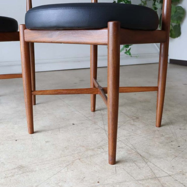 Set of four vintage G-plan mid-century dining chairs in teak with dark leather cushioned seats and slender rounded legs from .
