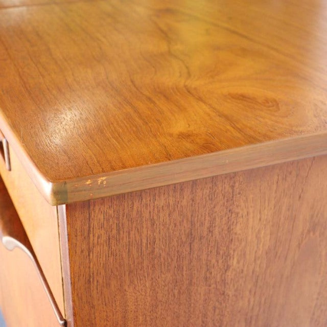 Close-up of vintage teak sideboard corner showing warm wood grain and smooth mid-century British craftsmanship with subtle.