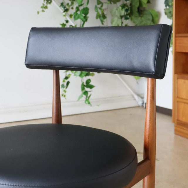 Set of four vintage G-plan dining chairs in teak with black leatherette seats and backrests, mid-century British design.