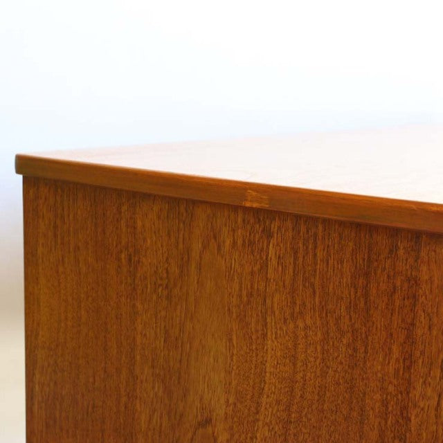 Mid-century vintage British teak sideboard corner showing smooth wood grain and clean lines.