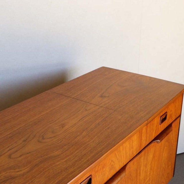 Mid-century British vintage teak sideboard with rich wood grain and clean lines against a neutral wall.