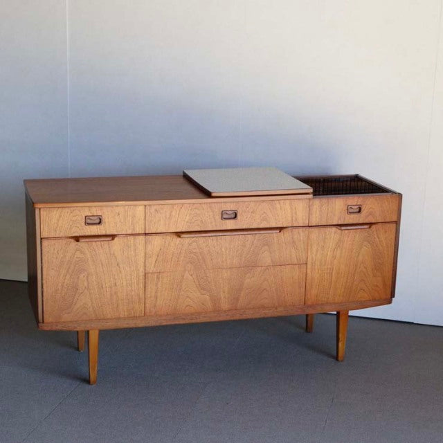Mid-century British vintage teak sideboard with rich wood grain, three drawers, and tapered legs from Denmark.
