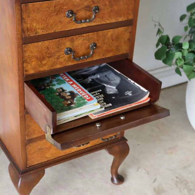 Vintage British teak record cabinet with rich wood grain, mid-century curved legs, open drawer holding vinyl records.