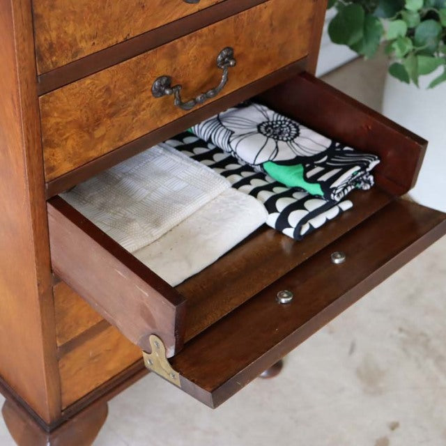 Vintage British teak record cabinet with mid-century style, rich wood grain, and brass handles, drawer partially open.