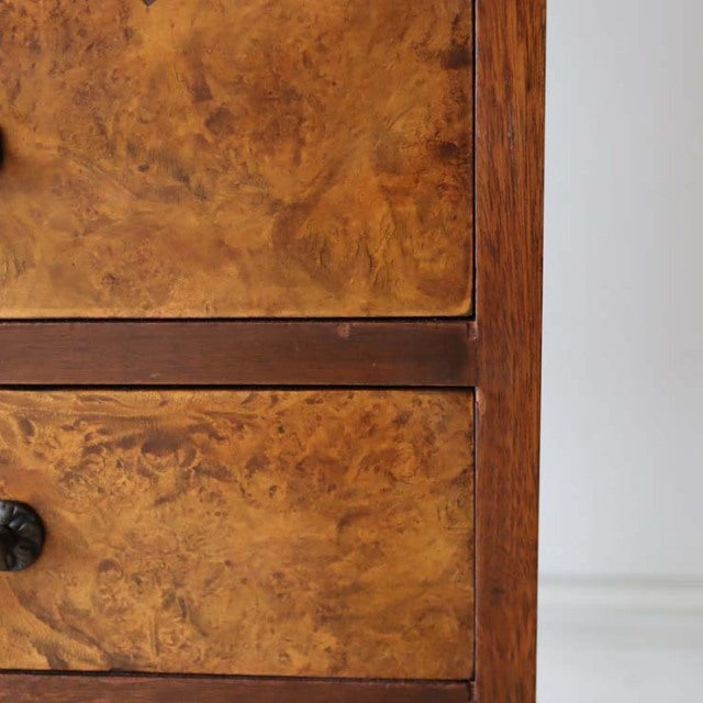 Close-up of vintage British mid-century teak record cabinet with rich wood grain and dark round knob on drawer, showcasing.