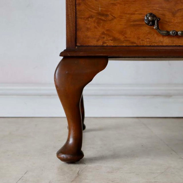 Close-up of vintage British walnut record cabinet leg with curved Queen Anne style and rich wood grain detailing.