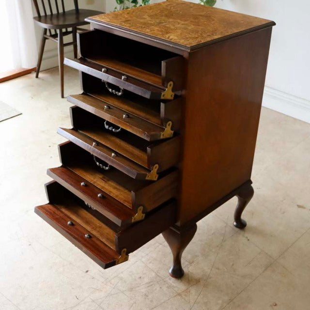 Vintage British teak record cabinet with five front-hinged drawers, mid-century form, detailed wood grain, and cabriole legs.