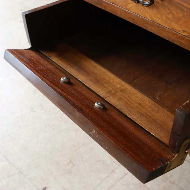 Mid-century British vintage teak cabinet drawer open, showing rich wood grain and round brass knobs.