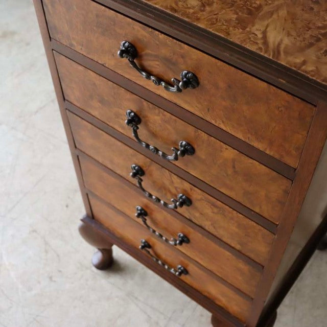 British vintage teak record cabinet with mid-century burl wood grain, ornate black metal handles, and curved legs.