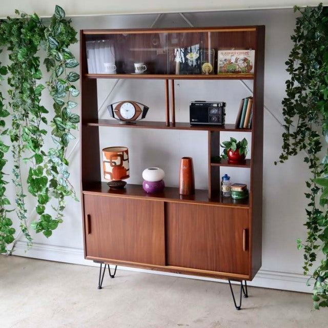Vintage teak mid-century room divider with British-Denmark design, iron hairpin legs, sliding cabinet doors, and rich wood.