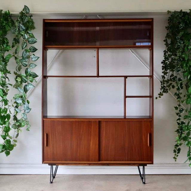 Vintage teak room divider from mid-century British design with iron hairpin legs, showcasing rich wood grain and open.