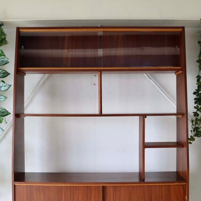 Vintage mid-century teak room divider with open shelving, British-Denmark design, exposed wood grain, and iron legs.
