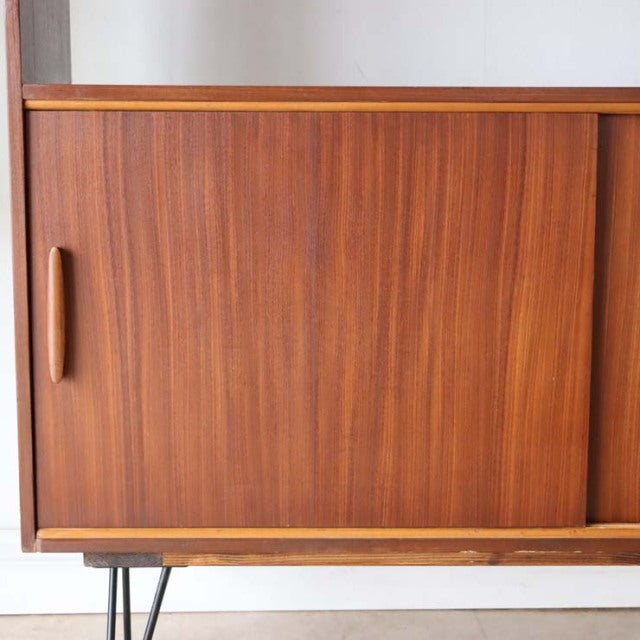 Vintage teak mid-century room divider with sliding doors, British design, featuring iron legs and rich wood grain from.