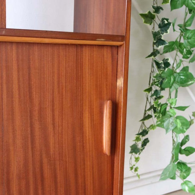 Vintage mid-century teak room divider with British design, showcasing rich wood grain and smooth rounded handle on iron legs.