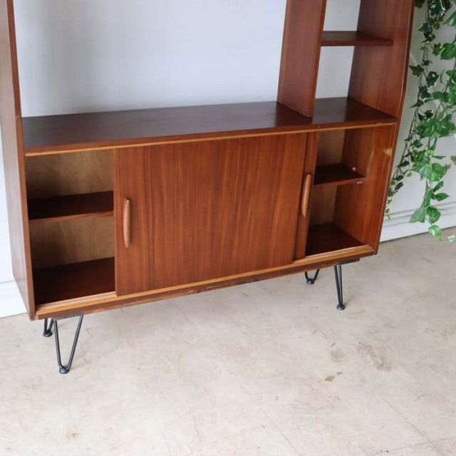 Vintage teak room divider cabinet with sliding doors, open shelving, and black iron hairpin legs, British mid-century design .