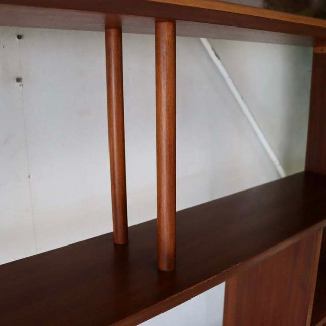 Mid-century British vintage teak room divider with smooth wood grain and slender iron-clad legs in Denmark style.