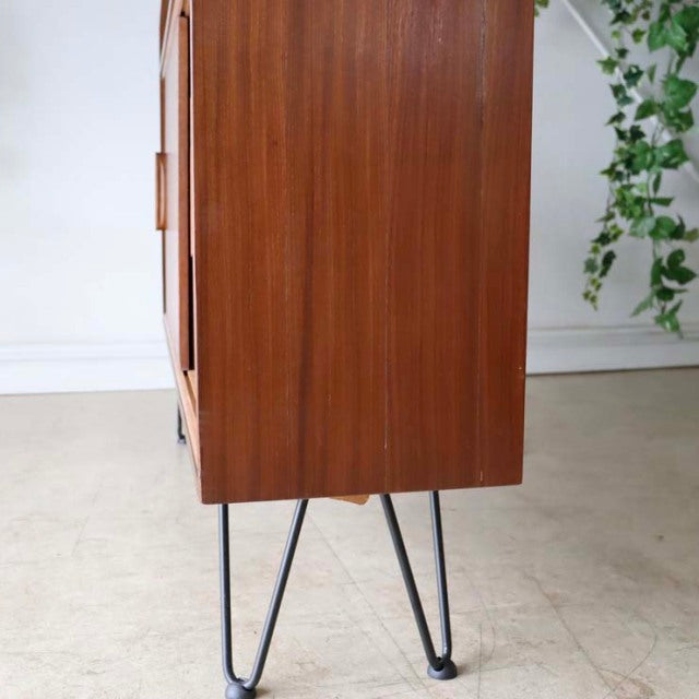Vintage teak mid-century British room divider with slender black iron legs, smooth wood grain visible on side panel.