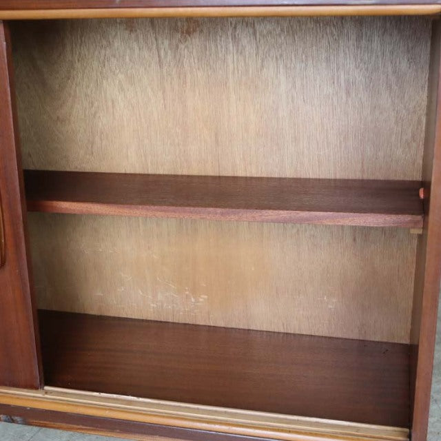 Mid-century vintage teak room divider with British design, smooth wood grain, iron legs visible inside cabinet.
