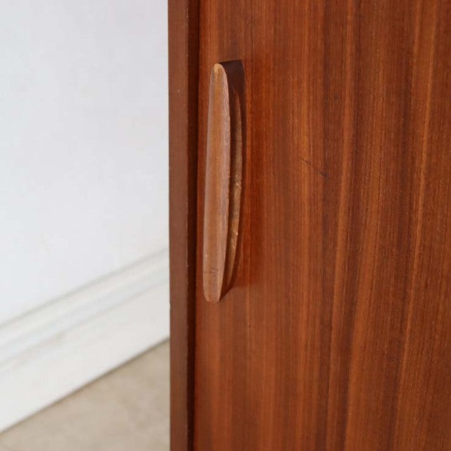 Close-up of teak wood grain and elongated oval handle on vintage British mid-century room divider panel.