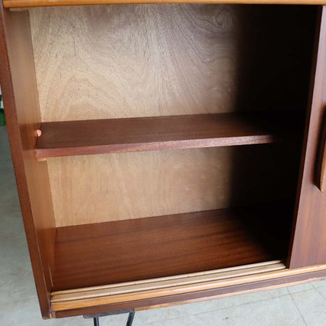 Vintage teak room divider cabinet with smooth wood grain, mid-century British design, iron legs visible at base.