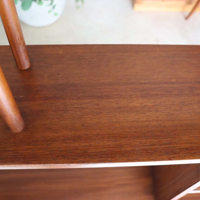 Mid-century British vintage teak room divider with visible wood grain and slender iron legs.