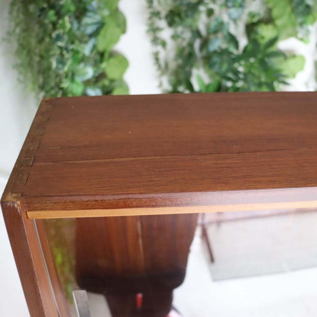 Vintage teak room divider with mid-century British design, showcasing rich wood grain and sturdy iron legs.