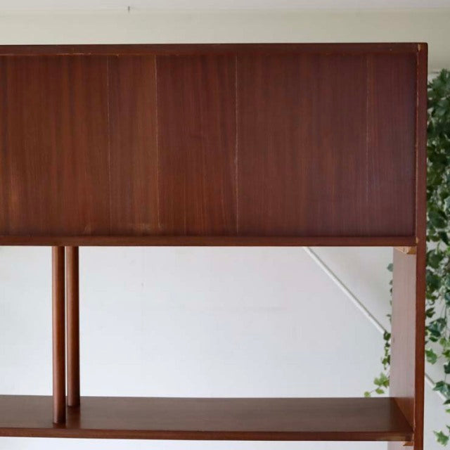 Vintage teak mid-century room divider with iron legs, showcasing warm wood grain and sleek British-Denmark design.