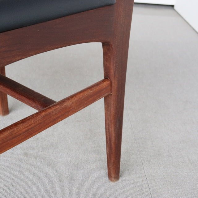 Close-up of teak wood leg with visible grain and mid-century British design, part of a vintage Younger Fonseca dining chair.