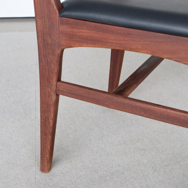Mid-century teak dining chair leg and frame with smooth wood grain and black leatherette seat from British Younger Fonseca.
