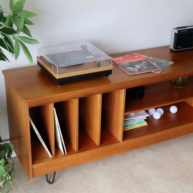 Mid-century British teak vintage TV board with rich wood grain, vertical record storage, open shelving, and slender iron.