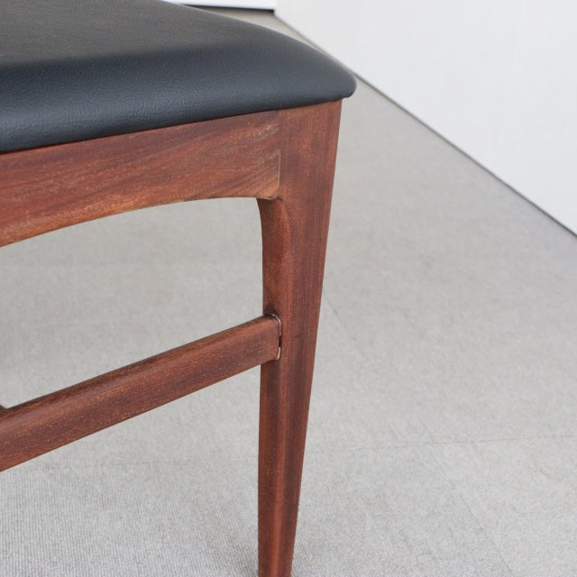 Vintage mid-century teak dining chair leg and frame with smooth grain and black leather seat upholstery from Younger Fonseca .