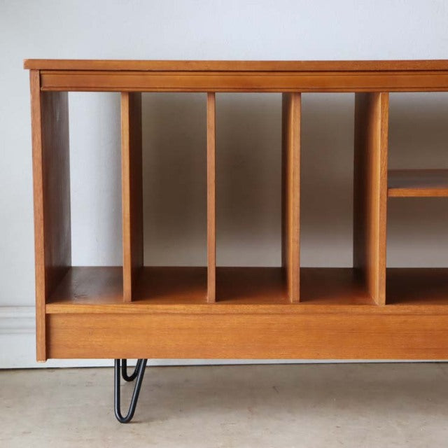 Vintage teak mid-century British TV board with vertical wood grain panels and slender black metal hairpin legs.
