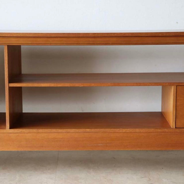 Mid-century teak TV board with vintage British design, featuring clean lines, natural wood grain, and slender iron legs in.