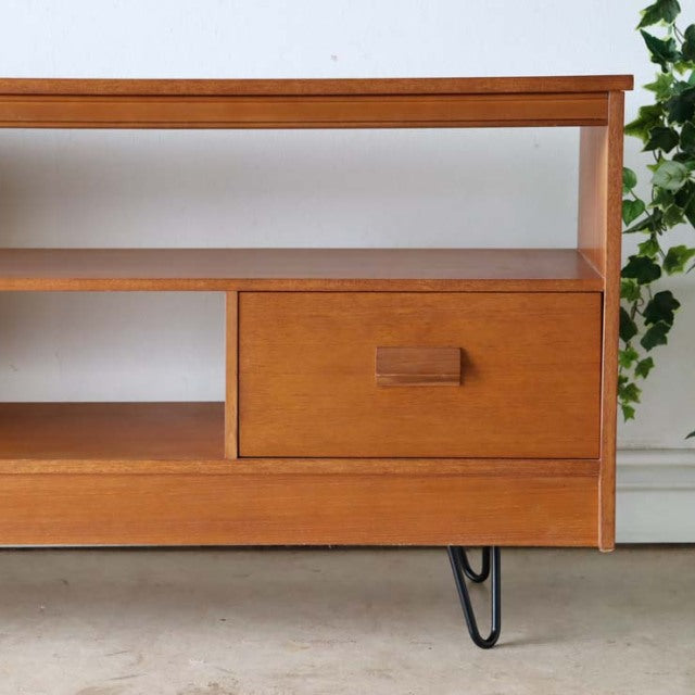 Vintage teak mid-century British TV board with smooth wood grain, rectangular drawer, and black iron hairpin legs.