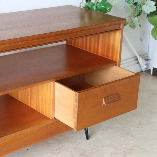 Vintage mid-century teak TV board with rich wood grain, British design, open shelf, and black iron legs.